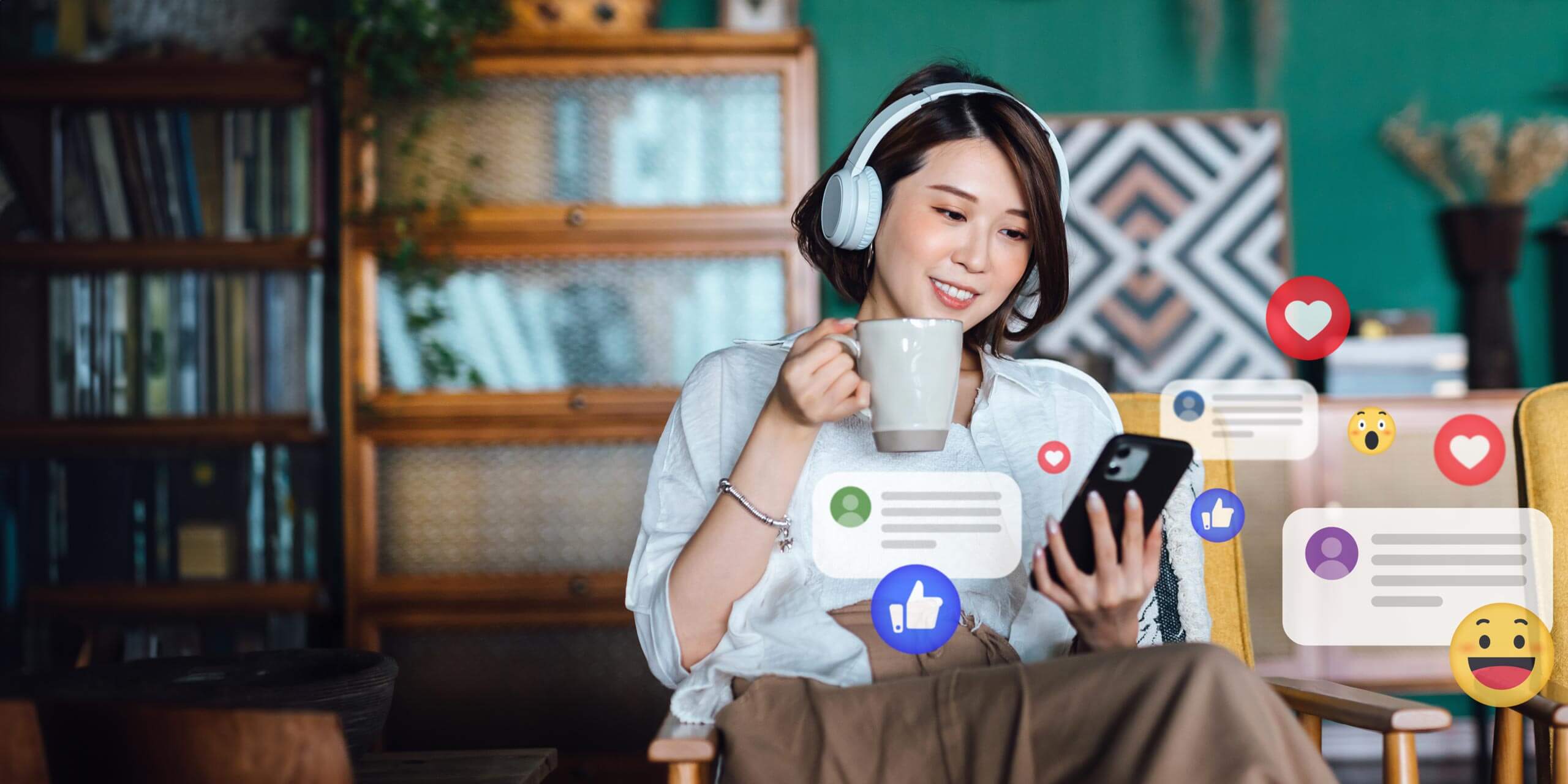 Eine Frau sitzt mit Kopfhörern in einem gemütlichen Raum, hält eine Tasse in der Hand und schaut auf ihr Smartphone. Um sie herum sind verschiedene Social-Media-Symbole wie Daumen hoch, Herz und lachendes Gesicht, die Benachrichtigungen und Reaktionen darstellen. Im Hintergrund sind Bücherregale und Pflanzen zu sehen.